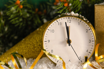 Golden Christmas alarm clock on snow, closeup