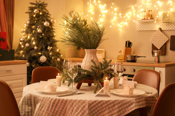 Dining table with beautiful setting for Christmas celebration in kitchen interior