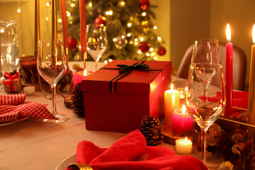 Festive Christmas table setting and gift box in room