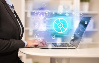 Hands working on laptop with digital icons