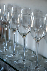 Many empty clean wine glasses on shelf in restaurant