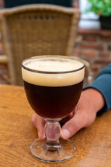 Glass of dark tasty Belgian dubbel brown beer from abbey brewery