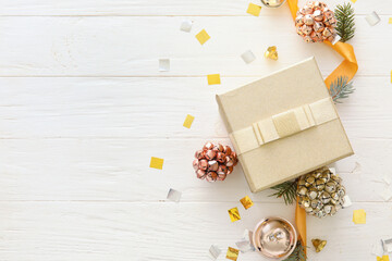 Beautiful composition with Christmas gift box and decor on white wooden background