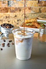 Iced Latte coffee with sweets with coffee beans on dark background