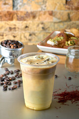 Iced Latte coffee with Arabic sweets and coffee beans on dark gray background