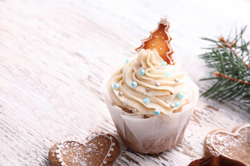 Delicious Christmas cupcake and cookies on white wooden background