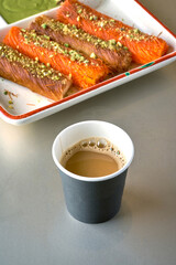 Turkish Coffee with sweets, kunafa rolls, with pistachio nuts on top on gray background