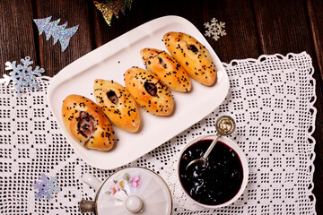 Meat pies on a white dish. Knitted tablecloth, jam. Tinting