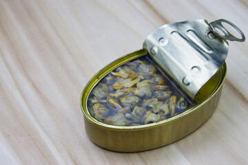 Image of a can with cockles on a wooden table
