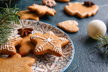 Plate with sweet Christmas gingerbread cookies on black background, closeup