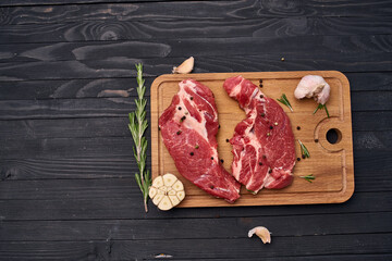 meat steak wooden board and spices ingredients top view