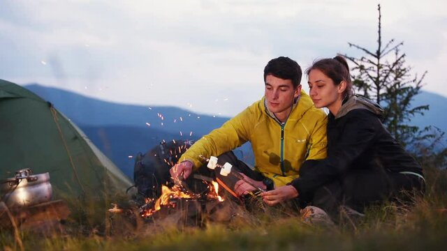 Preparing marshmallows from campfire. Majestic Carpathian Mountains. Beautiful landscape of untouched nature