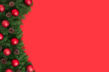 Fototapeta na wymiar Christmas red background with fir branches and red baubles. Happy new year. Space for text. Copy space, template. Top view, flat lay.