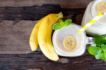 Banana fresh cocktail vanilla smoothies  fruit juice beverage healthy the taste yummy in glass drink episode good morning on wooden background from the top view.