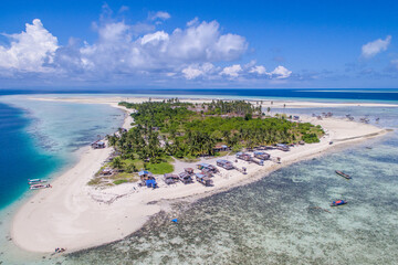 Aerial view of Maiga island panorama, beautiful blue lagoon and coral reef.