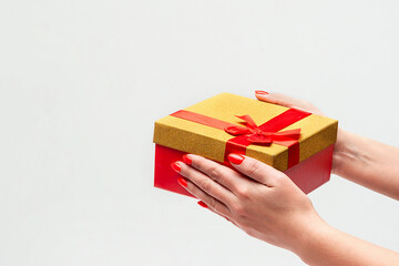 Gift box in female hands on a white background