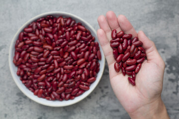 Grains Red bean on hand and in bowl put on concrete background