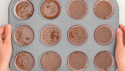 Chocolate cupcakes recipe. Cupcake pan lined with paper liners, and silicon molds filled with...