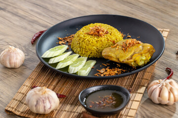 Rice with curried chicken. Delicious spicy chicken biryani in black bowl on wooden background, Indian or Pakistani ramzan food. Homemade Arabian biryani. Traditional spicy Indian food. chicken biryani