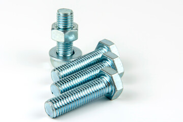 Large metal nuts with silver metal bolts. Close-up on a white background. A group of several nuts...