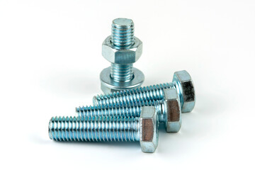 Large metal nuts with silver metal bolts. Close-up on a white background. A group of several nuts and bolts