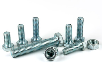 Large metal nuts with silver metal bolts. Close-up on a white background. A group of several nuts and bolts