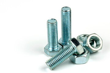 Large metal nuts with silver metal bolts. Close-up on a white background. A group of several nuts and bolts