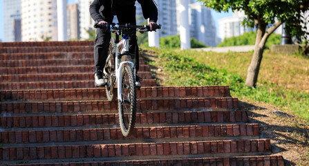 Woman free rider riding bike going down city stairs