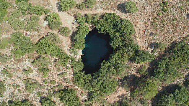 Aerial ascending view Natural clear water lake, Melissani cave, Greece