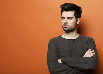 Photo of thoughtful man isolated over orange color background wall.
