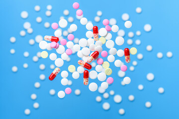 Flying pills and levitation tablets on blue background. Medicine and healthcare concept.
