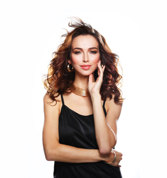 Beautiful model woman with wavy hairstyle, wearing black dress over white background.