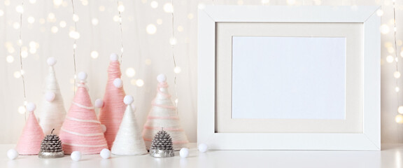 Banner with Diy Christmas trees made of pink yarn and white frame on table. Front view mockup. Eco fluffy Christmas decoration