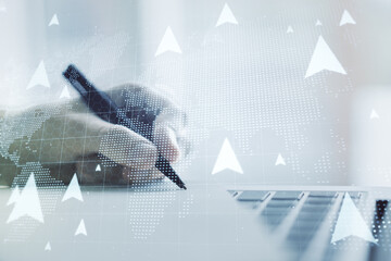 Creative concept of geolocations map and hand writing in notebook on background with laptop. GPS tracking and navigation concept. Multiexposure