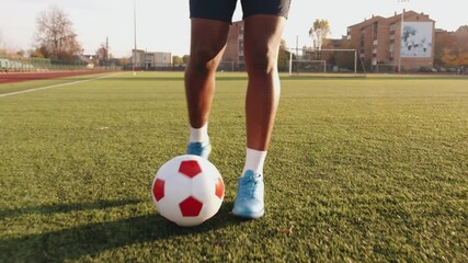 Close-up of a legs of a black soccer player practicing ball possession in a training session. Football dribbling