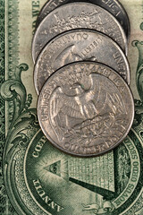 A closeup of quarters on a dollar bill