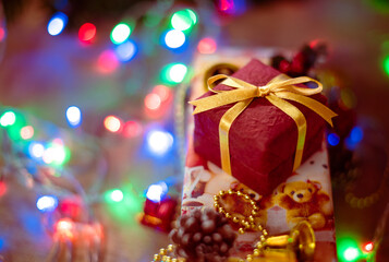 Beautiful Christmas gift boxes. Colored Presents for Birthdays. Boxes with gifts tied with ribbon and bows background. craft paper present box. Christmas tree toys and lights. happy new year 