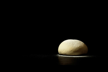 dough for pizza or bread on a black background