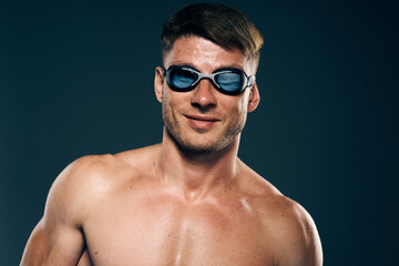 sports man with naked torso swimmer professional dark background