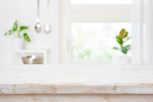 Wooden table on defocused kitchen window background with copy space