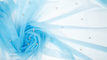 fashion blog concept. swirling light blue tulle with small beads pearls.Textured background for atelier. Abstract pattern wallpaper for the fashion industry.