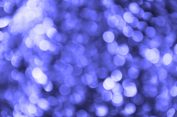 Fototapeta na wymiar Abstract background with glowing blurred color Very Peri circles. Bokeh in colors of 2022. Glitter vintage lights background. Defocused. Festive new year and Christmas background with violet lights