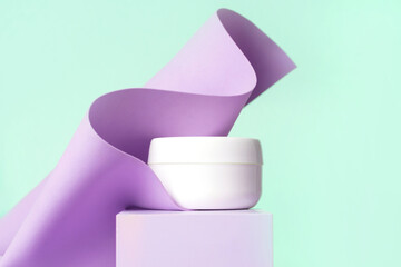 Jar of cosmetic cream on modern abstract podium, pastel mint purple background. Copy space...