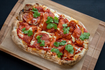 Tasty pizza on black background. Delicious pepperoni pizza. Enjoying time with friends and tasty food.
