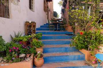 Fototapeta na wymiar Small narrow street with blue stairs in Old Town of Rethymnon, Crete island, Greece
