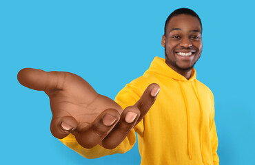 Happy black guy showing big outstretched hand, offering help, taking or giving something, reaching...