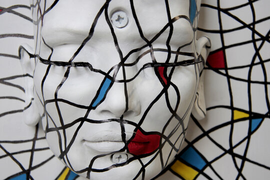 White statue face. Sculpture of female, beautiful features with closed eyes. Abstract texture, primary colors.