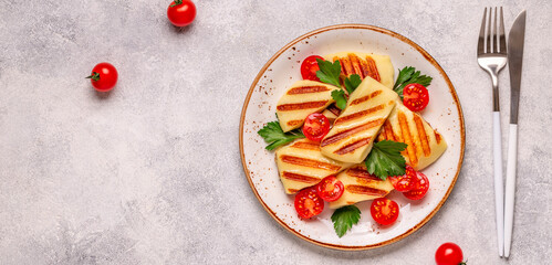 Grilled halloumi cheese served with tomatoes and parsley