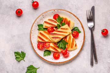 Fototapeta na wymiar Grilled halloumi cheese served with tomatoes and parsley