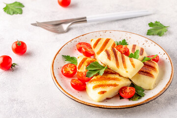 Grilled halloumi cheese served with tomatoes and parsley